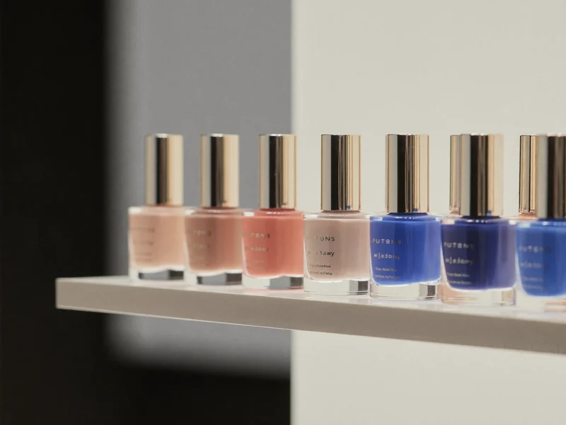 Reihen unbeschrifteter Nagellackfläschchen in Nude, Rosé und Kobaltblau (Illustration)
